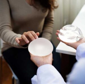 Two people compare different types of breast implants during a breast implant consultation in San Diego, CA.